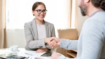 Eine junge Frau reicht einem Personaler die Hand